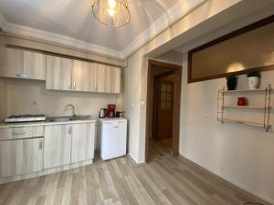 a kitchen with white cabinets and a white refrigerator at Distinguished Flat near Pera Museum in Beyoglu in Istanbul