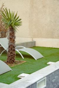 a palm tree and a white table and chairs at La Plume argentée ONLY WOMEN femmes uniquement in Vénissieux