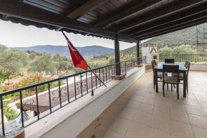 einen Balkon mit einem Tisch, Stühlen und einer Flagge in der Unterkunft Refreshing Villa near Milas-Bodrum Airport in Gulluk