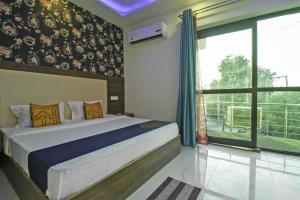 a bedroom with a bed and a large window at SPOT ON Hotel White Rose in Zirakpur