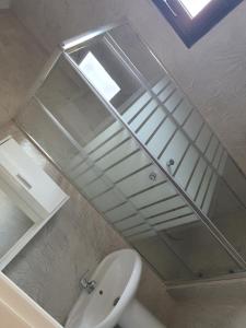 uma casa de banho com um lavatório, um espelho e um WC. em Island apartment N.Skioni em Nea Skioni