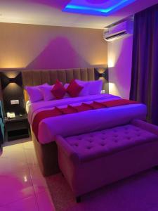 Dormitorio púrpura con cama con iluminación púrpura en NO 95 SUITES VI en Lagos