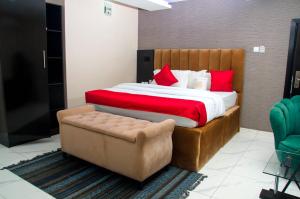 a bedroom with a large bed and a chair at NO 95 SUITES VI in Lagos