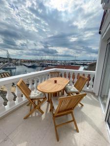 a table and chairs on a balcony with a view of a harbor at Riva House Tribunj in Tribunj