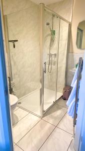 a shower with a glass door in a bathroom at Bramall House Accommodation in Fewston