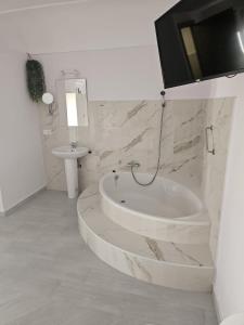 ein weißes Badezimmer mit einer Badewanne und einem Waschbecken in der Unterkunft Hostal Pompeya Merida in Merida