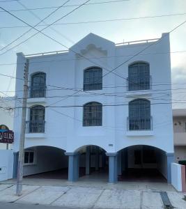 ein weißes Gebäude mit einem Torbogen davor in der Unterkunft Suites San Luis in Mazatlán