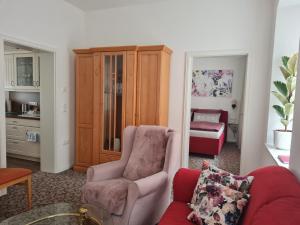 ein Wohnzimmer mit einem Sofa und einem Stuhl in der Unterkunft K5-Suites in der Altstadt Annaberg-Buchholz in Annaberg-Buchholz