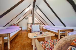 a attic room with four beds and a table at Kuća za odmor s bazenom TeriHy in Klake
