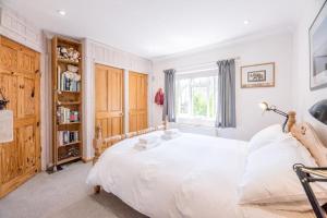 um quarto com uma grande cama branca e uma janela em Number 27, Alderton em Woodbridge