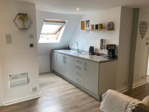 a kitchen with white cabinets and a sink and a window at Rother - Studio in Rye - LOCATION,LOCATION,LOCATION !!! in Rye