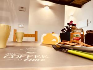 - une table avec une assiette de nourriture et une tasse de café dans l'établissement Laura Guest House Sasso di Castalda, à Sasso di Castalda