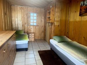 two beds in a room with wooden walls at Azyl nad Potokiem in Karpacz