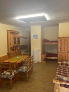 a room with a table and chairs and bunk beds at Il Covo House in Roccaraso