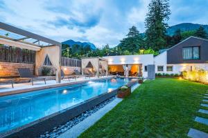Un patio trasero con piscina y una casa. en Merangardenvilla adults only, en Merano