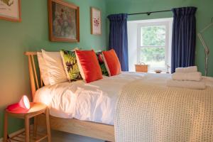 a bedroom with a white bed with colorful pillows at Exclusive use - The Coach House in Banchory