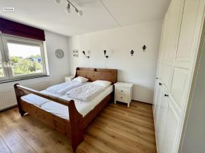 Schlafzimmer mit einem Bett und einem Fenster in der Unterkunft Duinerei appartement A101 in Groote Keeten