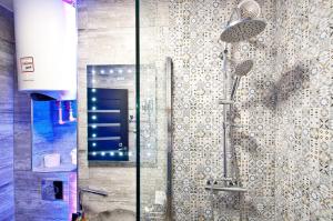 La salle de bains est pourvue d'une douche avec une porte en verre. dans l'établissement Boutique Apartments, à Galaţi