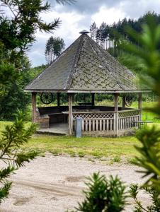 a wooden gazebo in a field with at Koselig hytte langs elven in Skien
