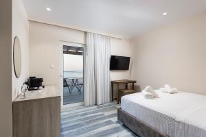 a hotel room with a bed and a view of the ocean at Kyma Rooms & Suites in Kardamaina