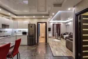 a kitchen and living room with a stainless steel refrigerator at Viktoria Garden apartment in Lviv