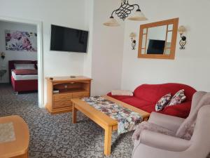 Sala de estar con sofá rojo y mesa de centro en K5-Suites in der Altstadt Annaberg-Buchholz, en Annaberg-Buchholz