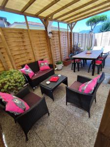 un patio con sillas y una mesa con almohadas rosas en House Viareggio en Viareggio