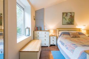 a bedroom with a bed and a dresser and a window at The Secret Garden in Kingsdown