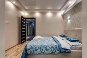 a bedroom with a large bed with blue sheets and pillows at Viktoria Garden apartment in Lviv