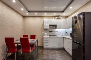 a kitchen with a table and chairs and a refrigerator at Viktoria Garden apartment in Lviv +13 photos