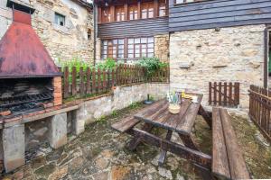 una mesa de picnic de madera en un patio con chimenea en Montegrande, entorno mágico rodeado de montañas, en La Plaza