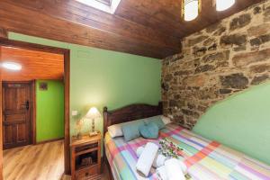 1 dormitorio con cama y pared de piedra en Montegrande entorno mágico rodeado de montañas en La Plaza