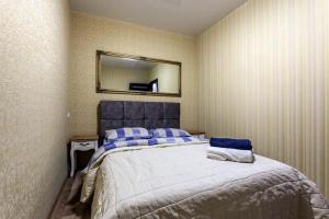 a bedroom with a large bed with a mirror on the wall at Viktoria Garden apartment in Lviv