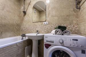 a bathroom with a washing machine and a sink at Viktoria Garden apartment in Lviv