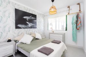 1 dormitorio con 1 cama con colcha verde en Acogedor Apartamento con vistas al mar en Costa Adeje, en Adeje