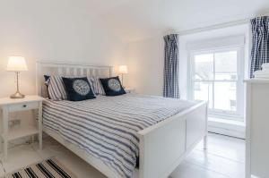 um quarto branco com uma cama e uma janela em Norton Cottage - 3 Bedroom Cottage - Tenby em Tenby