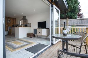 eine Terrasse mit einem Tisch und Stühlen sowie eine Küche in der Unterkunft The Garden Lodge - 1 Bedroom Lodge - Tenby in Tenby