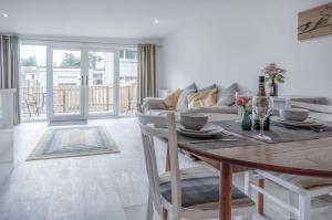 a dining room with a table and a couch at The Garden Lodge - 1 Bedroom Lodge - Tenby in Tenby