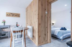 Cette chambre dispose d'une cloison en bois avec une table et un lit. dans l'établissement The Garden Lodge - 1 Bedroom Lodge - Tenby, à Tenby
