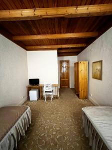 Un dormitorio con 2 camas y un escritorio en una habitación. en Hotel Caravan Serail, en Samarkand