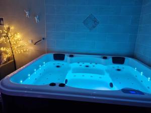 baño con bañera azul y árbol de Navidad en Chambres d'hôtes avec jacuzzi privatif en Westrehem