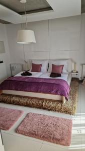 a bedroom with a large bed with purple sheets and pillows at OrangeHomes One bedroom apartment with fireplace in Budapest