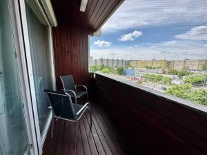 a balcony with two chairs sitting on a deck at OrangeHomes One bedroom apartment with fireplace in Budapest