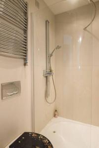 a bathroom with a shower and a toilet and a tub at OrangeHomes One bedroom apartment with fireplace in Budapest