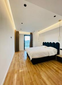 um quarto com uma cama grande e piso em madeira em 19th floor Apartment em Cluj-Napoca