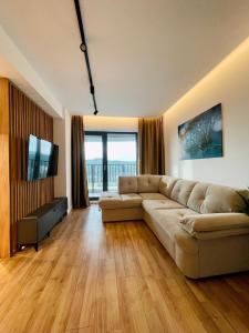 uma sala de estar com um sofá e uma televisão de ecrã plano em 19th floor Apartment em Cluj-Napoca