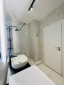 uma casa de banho com um WC, um lavatório e um chuveiro em 19th floor Apartment em Cluj-Napoca