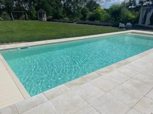 basen z błękitną wodą na dziedzińcu w obiekcie Noble Apartment & Sauna ZONE w Zabierzowie