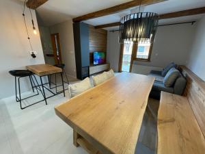 ein Wohnzimmer mit einem Holztisch und einem Sofa in der Unterkunft Apartment Lana in Kranjska Gora