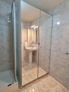 a bathroom with a sink and a glass shower at Plaza Mostenses en Plaza España in Madrid